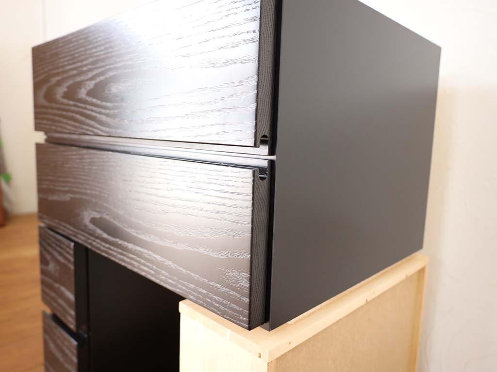本体は黒ポリ材、引き出しの前板は無垢材を使用